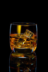 glass of scotch whiskey with ice on black background