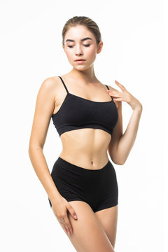 Slim slender woman in black underwear posing against white background. Wellness and body care concept. Healthy lifestyle