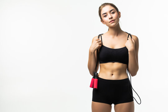 Young woman in black underwear with a jump rope isolated on white background