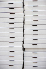 Front view of a high stack of neutral white flat delivery boxes