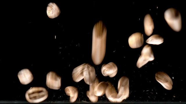 Close-up Coffee Beans falling down on table in slow motion with black background