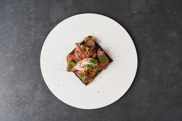  Smorrebrod with roast beef and remoulade sauce on a white plate