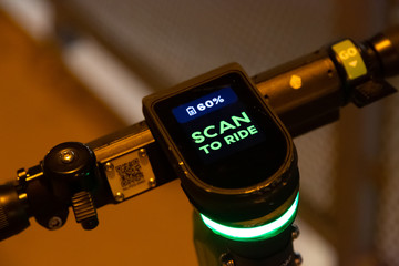 electric scooter shows the battery charge level and the prompt "Scan To Ride".