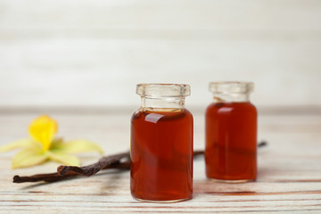 Aromatic homemade vanilla extract on white wooden table