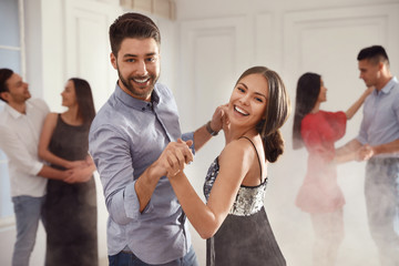 Lovely young couple dancing together at party - obrazy, fototapety, plakaty