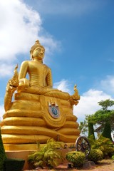 Golden statue of a sitting buddha, flanked by two Naga serpents in Thailand.