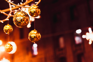 Golden Christmas balls. Christmas decoration outside. Bokeh background with space for text..