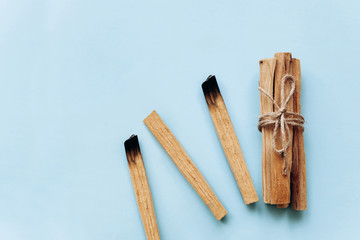 Palo Santo sticks on a blue background. They are used in aromatherapy and religious rites and meditations.