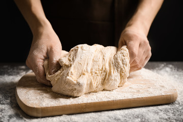 Woman with dough at grey table, closeup. Making pasta