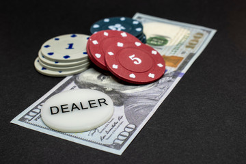 Poker chips on us dollar bill. Isolated on black background.