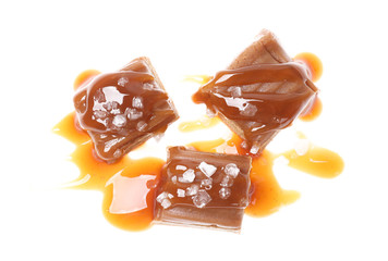 Delicious salted caramel with sauce on white background, top view