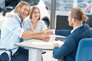 Obraz premium Salesman and client shaking hands after rental car deal