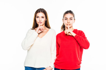 Two teen girl with silence gesture isolated on white background