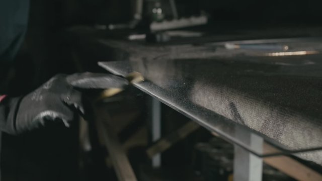 Forge. Smithy. Glass cutting and processing for fireplace doors. Circular glass cutter. Worker cut glass with glass cutting diamond. Polish an angle grinder with an abrasive circular disk nozzle.