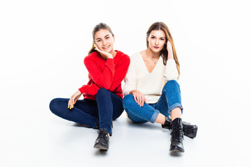 Fototapeta na wymiar Two teen girl friends have fun sitting on the floor isolated on white background