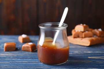 Salted caramel in jar on blue wooden table