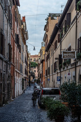 Streets of historic center of Rome, building, local people and tourists walking in city on narrow streets of old town in Rome, Italy