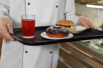 School canteen worker with tasty food near serving line, closeup