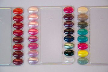 Multicolored nail polish samples, color palette in beauty salon. Manicure, fashion and stylish colors. Top view, flat lay