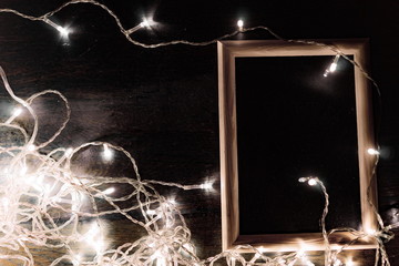 wooden frame with a light garland on a black background