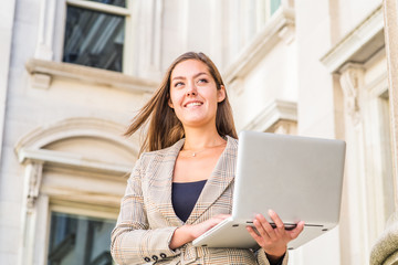 Way to Success. Young East European woman with long brown hair, wearing patterned blazer, holding...