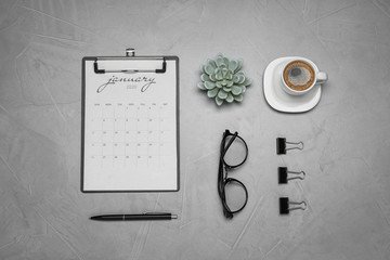Flat lay composition with calendar and cup of coffee on grey table