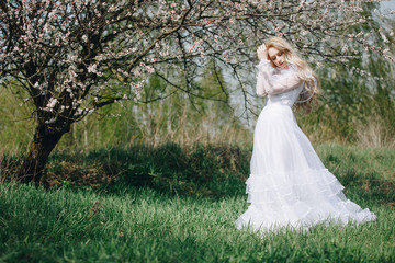 beautiful young woman with long blonde hair in blossom park