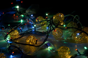Garland with colored lights close-up lies on a flat surface. Selective focus.