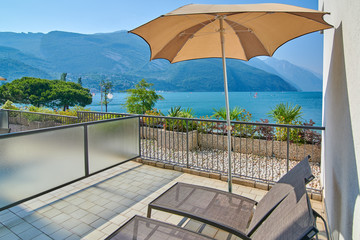 Deck chairs on the balcony, Lake Garda in summer, View of the beautiful Lake Garda from Torbole, surrounded by mountains