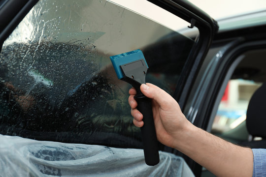 Worker Washing Tinted Car Window In Workshop, Closeup