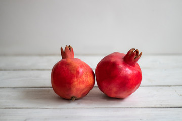 Pomegranates on a background of white boards. Fruit background.