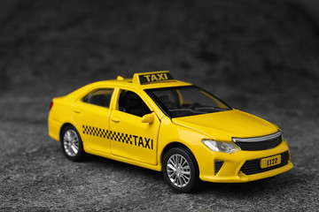 Yellow taxi car model on grey background