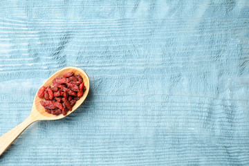 Dried goji berries on blue wooden table, top view. Space for text