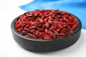 Dried goji berries on white wooden table, closeup