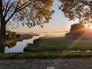 Fototapeta na wymiar Fog over the meadows during sunrise in the polder of Nieuwerkerk aan den IJssel in the Netherlands