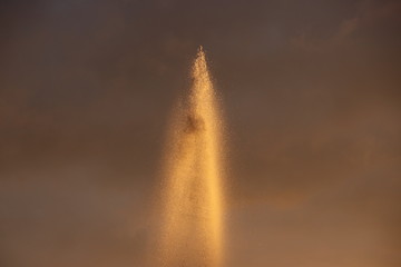 Water of a fountain illuminated by the sunlight during sunset