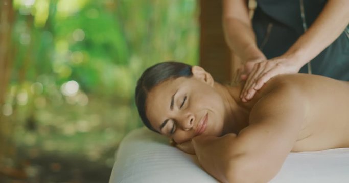 Attractive multi ethnic woman receiving a massage at a resort spa, blissful spa day, spa health and wellness concept