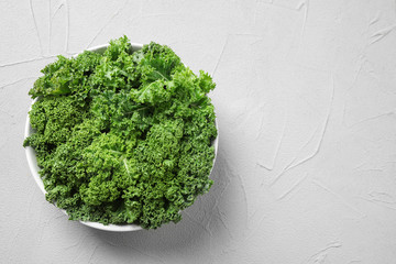 Fresh kale leaves on white table, top view. Space for text