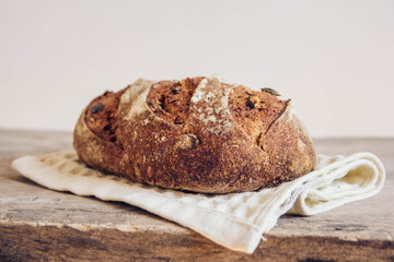 Brown fresh bread with seeds on old wood background. Top view, copy space