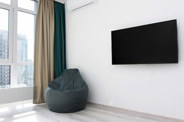 frameless gray armchair near the TV window Scandinavian design, bedrooms, interior, minimalism