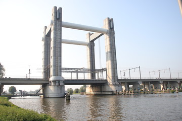 vertical lift bridge of concrete over river Gouwe in Gouda for trains named Gouwespoorbruggen in the Netherlands