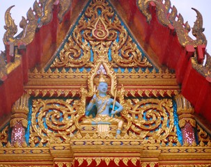 Fototapeta na wymiar Sculpture of a buddhist deity at Wat Chaithararam temple complex in Phuket, Thailand.