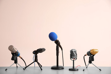 Naklejka premium Different microphones on light grey table. Journalist's work