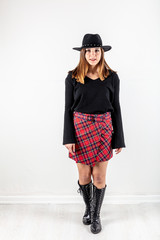 Young beautiful woman in warm knitted handmade (mini skirt and sweater) clothes at home. Model fashion shooting. Autumn, winter season.