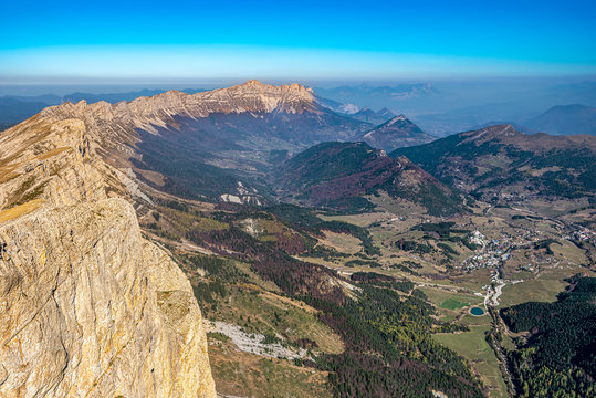 Ridges of Vercors as seen from Grand Veymont mountain summit, dominating the valley of Vercors Regional Natural Park and Gresse-en-Vercors village. Auvergne-Rhone-Alpes region in France.