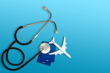 international medical travel insurance concept, stethoscope, passport and airplane isolated on blue background
