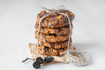 Delicious oatmeal cookies with chocolate on white table background. Copy, empty space for text