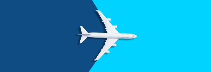 Foto op Plexiglas Platliggend ontwerp van reisconcept met vliegtuig op blauwe achtergrond met kopieerruimte © Angelov