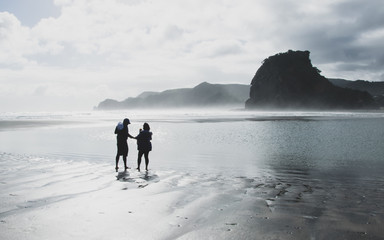 couple walking on the beach at sunset