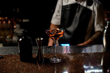 Delicious brown transparent alcoholic cocktail drink with the one big ice cube in the glass